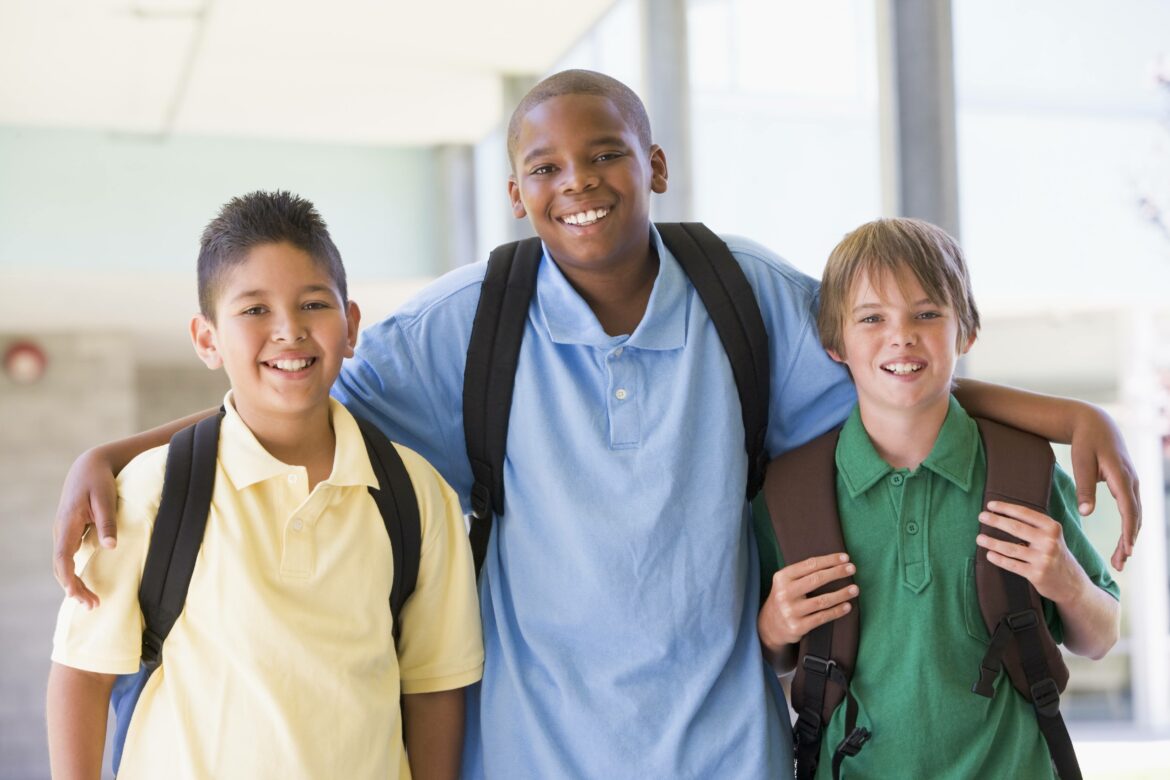 Three school age boys with backpacks.