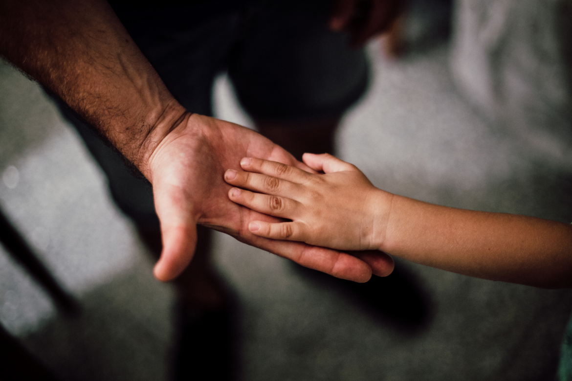 Child's hand on adult hand