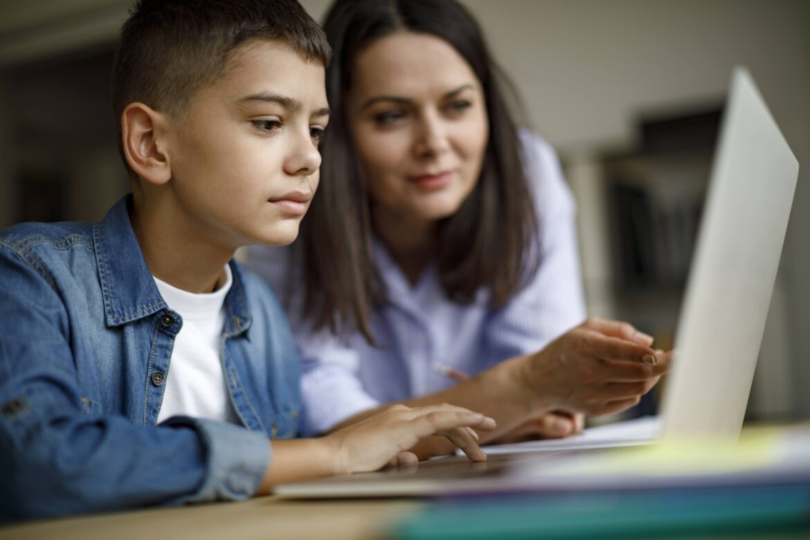 Mother an son using laptop at home