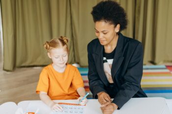 Clinician with neurodivergent youth sitting at a table working